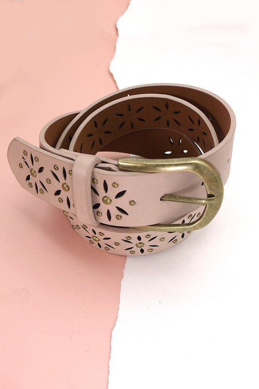 Decorative belt with floral cutout design and gold buckle on a pink background