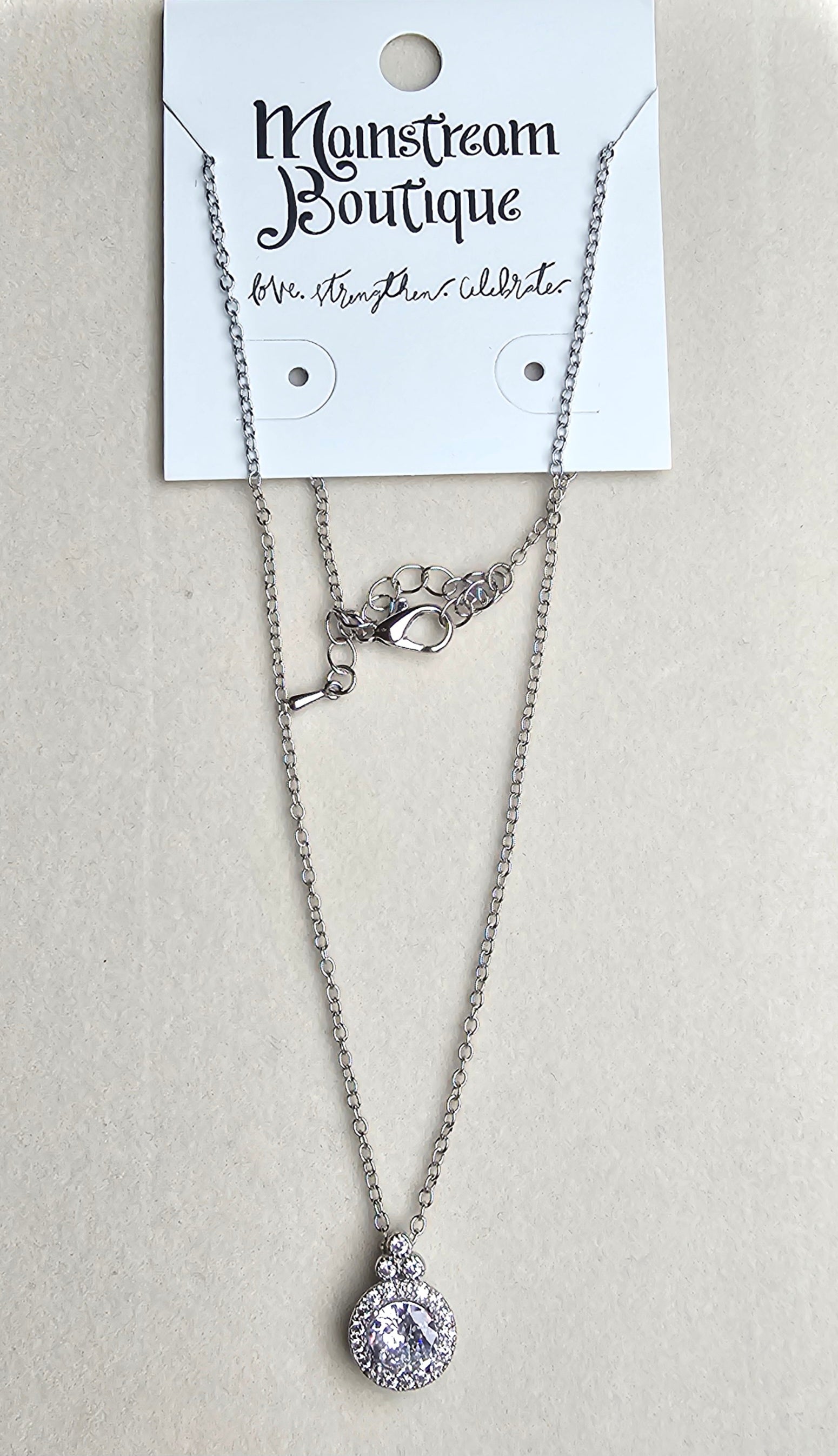 Necklace with a teardrop pendant on a card labeled 'Mainstream Boutique' against a beige background