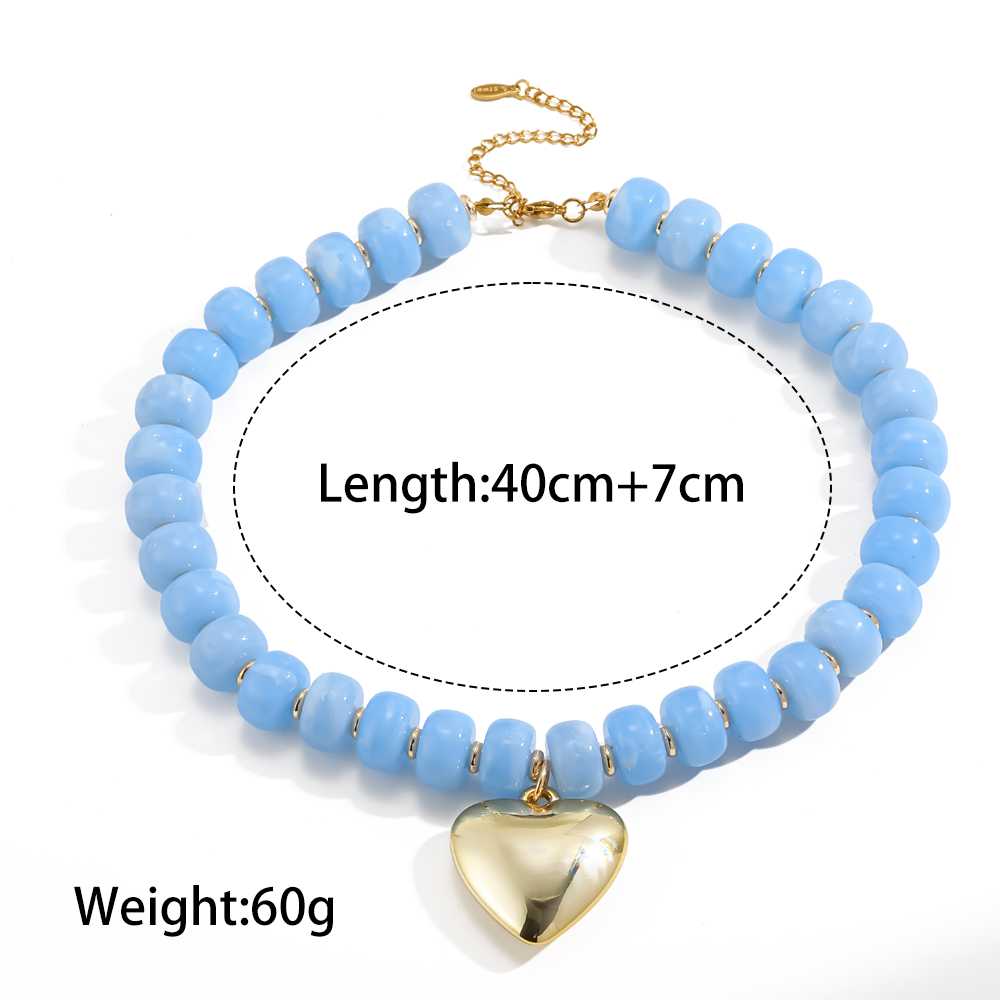 A light blue beaded necklace with a gold heart pendant and chain clasp, shown on a white background with printed text indicating length and weight.