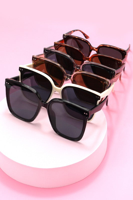 Set of sunglasses with different lens colors on a pink background