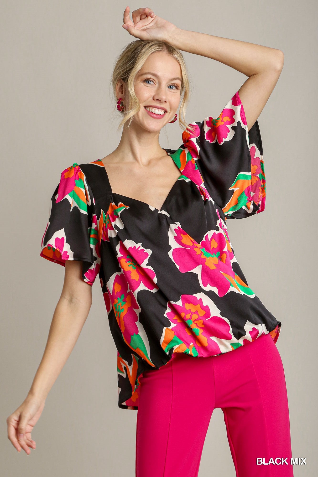 Woman wearing a colorful floral blouse with black background