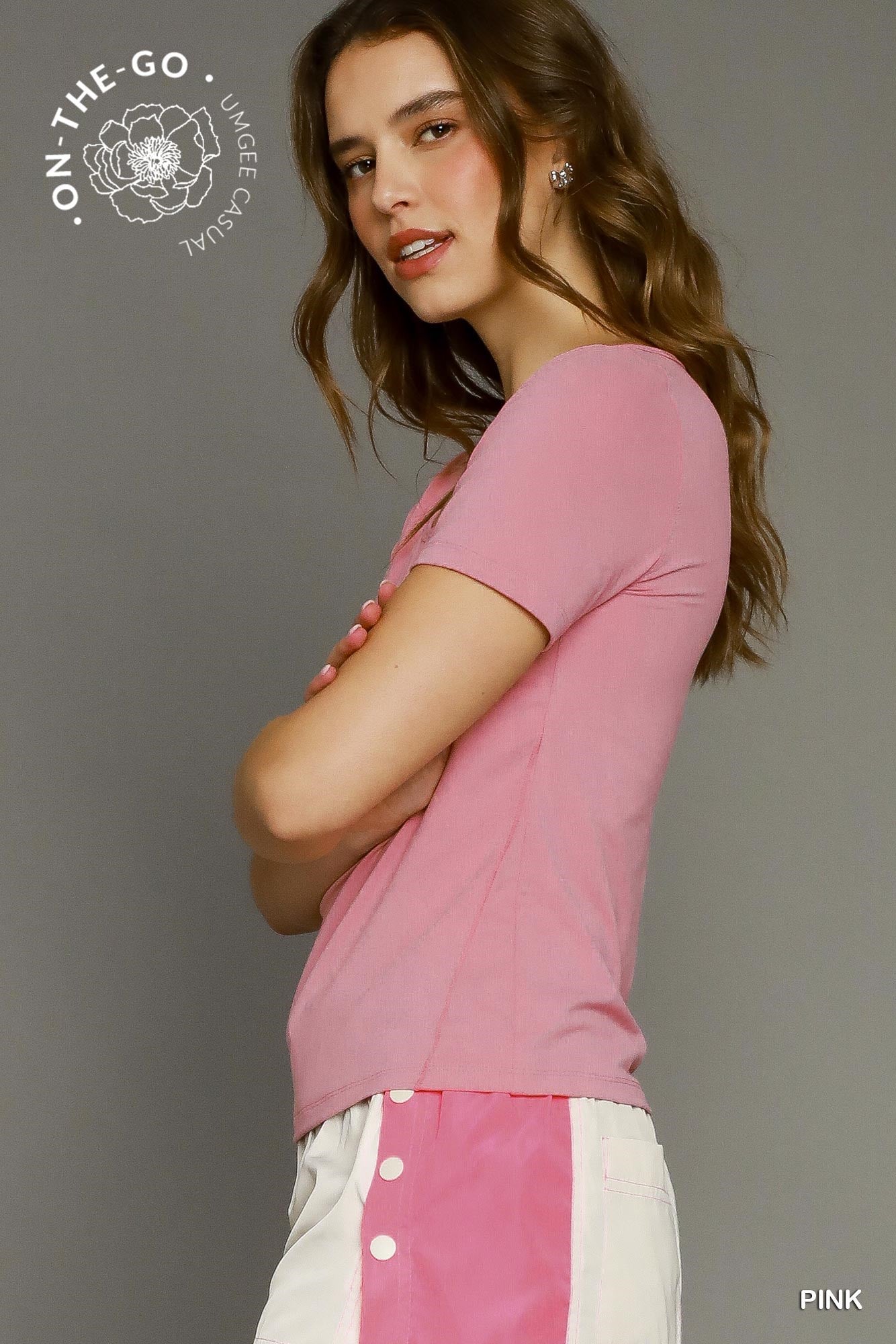 Woman wearing a pink shirt with a gray background and 'On-The-Go' logo.