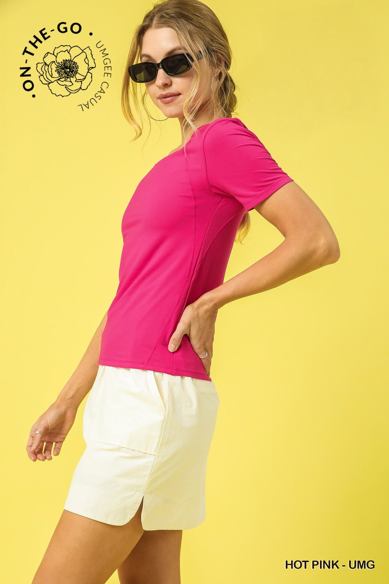 Woman wearing a pink shirt and white shorts on a yellow background with 'On-The-Go' branding.