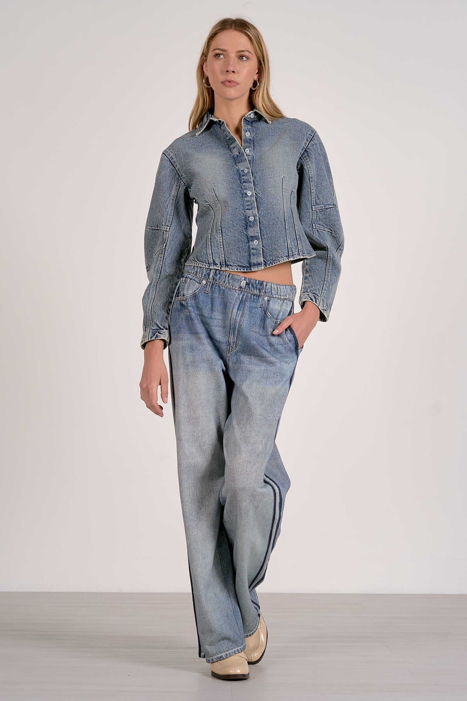 Woman wearing a denim outfit on a plain background