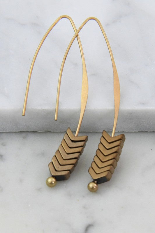 Gold and bronze chevron earrings on a marble surface
