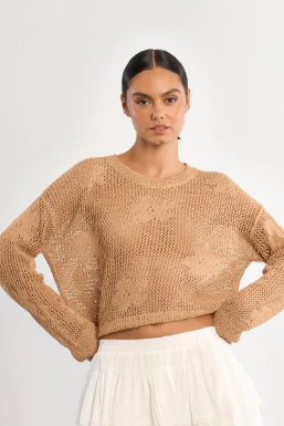 Woman wearing a beige knitted sweater on a white background
