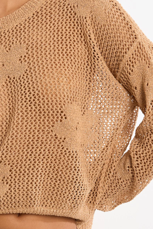 Close-up of a beige knit sweater on a white background