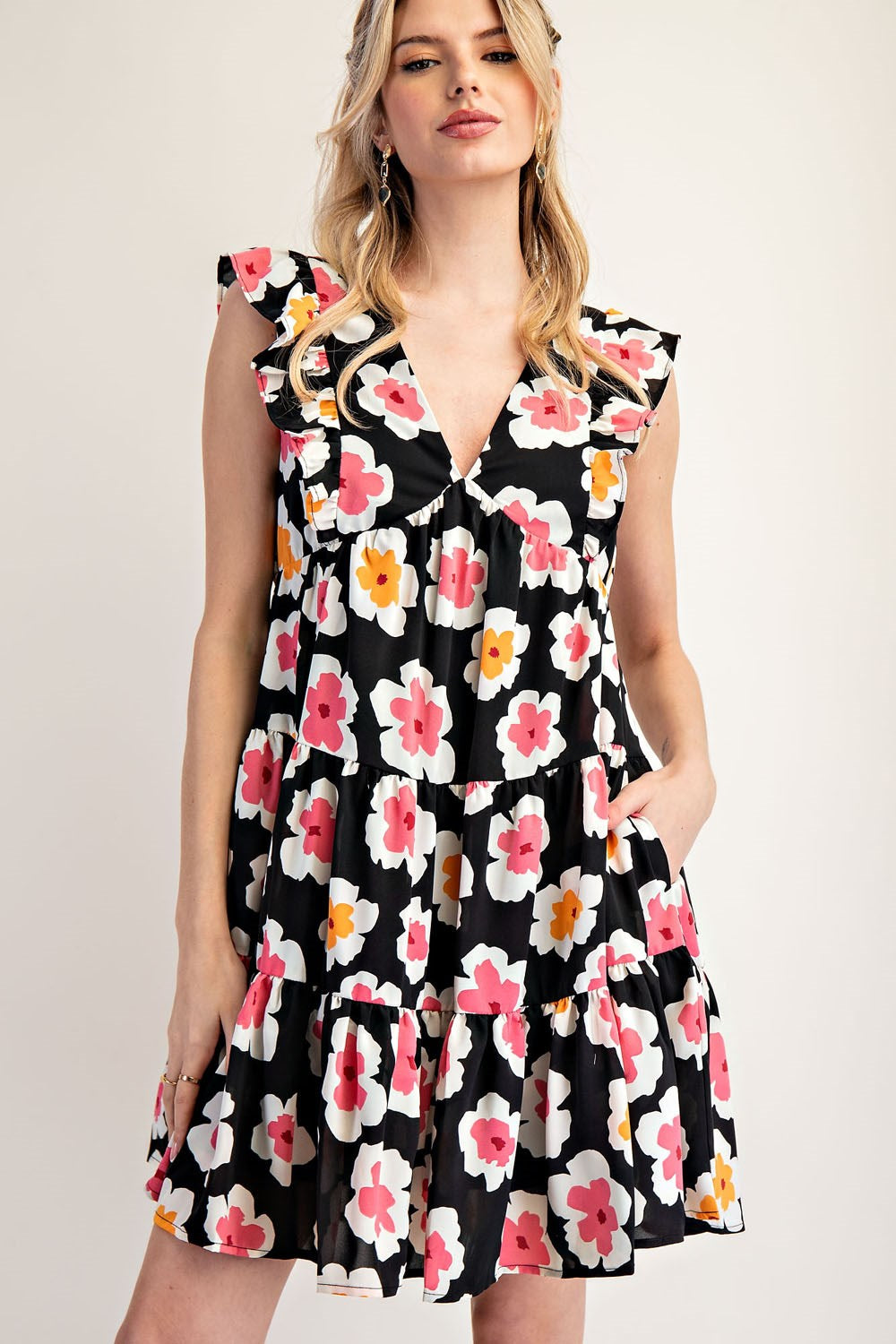 Woman wearing a black floral dress against a plain background