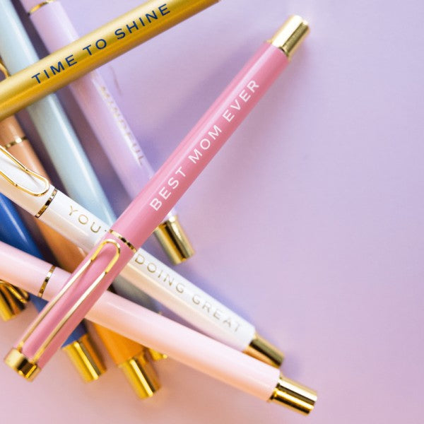 Colorful pens with motivational phrases on a pink background