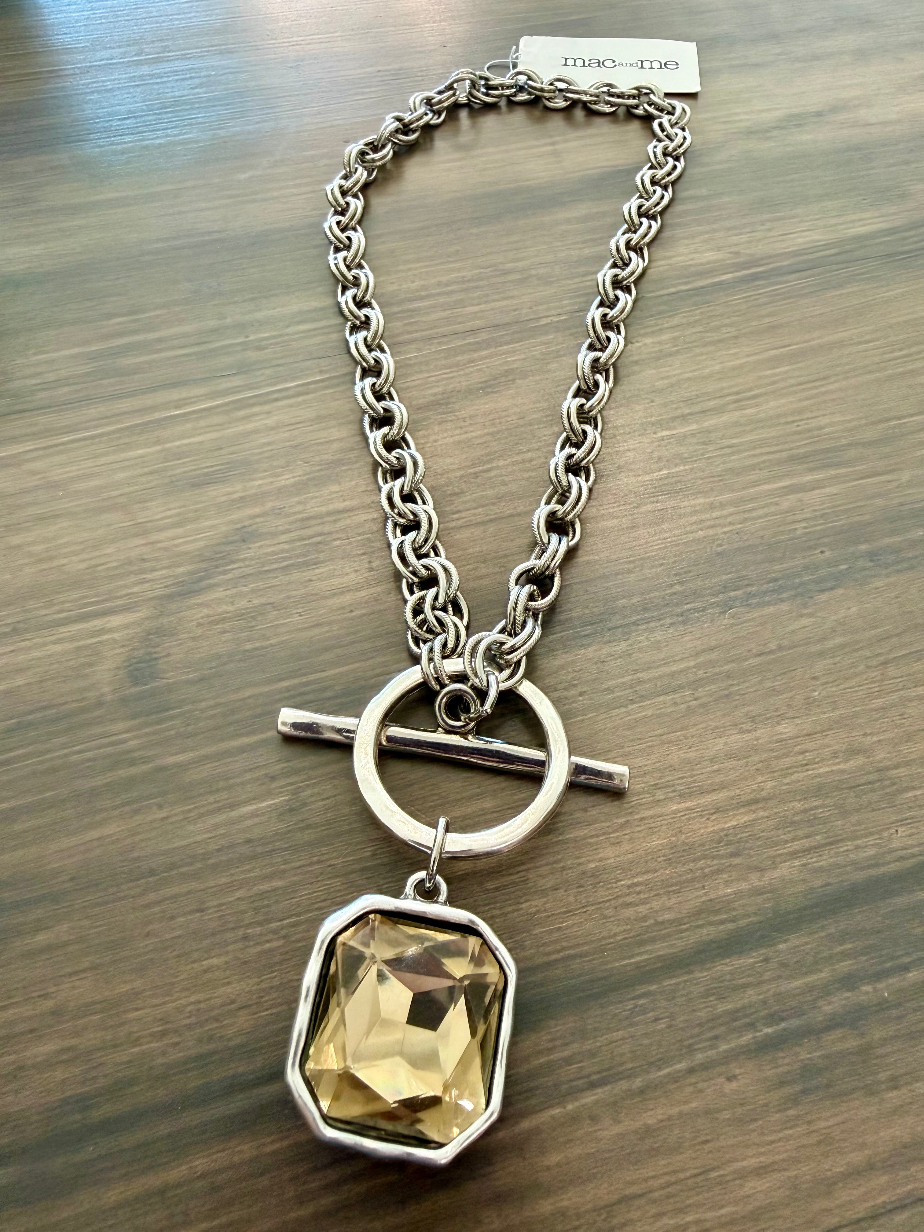 Necklace with a yellow gemstone pendant on a wooden surface