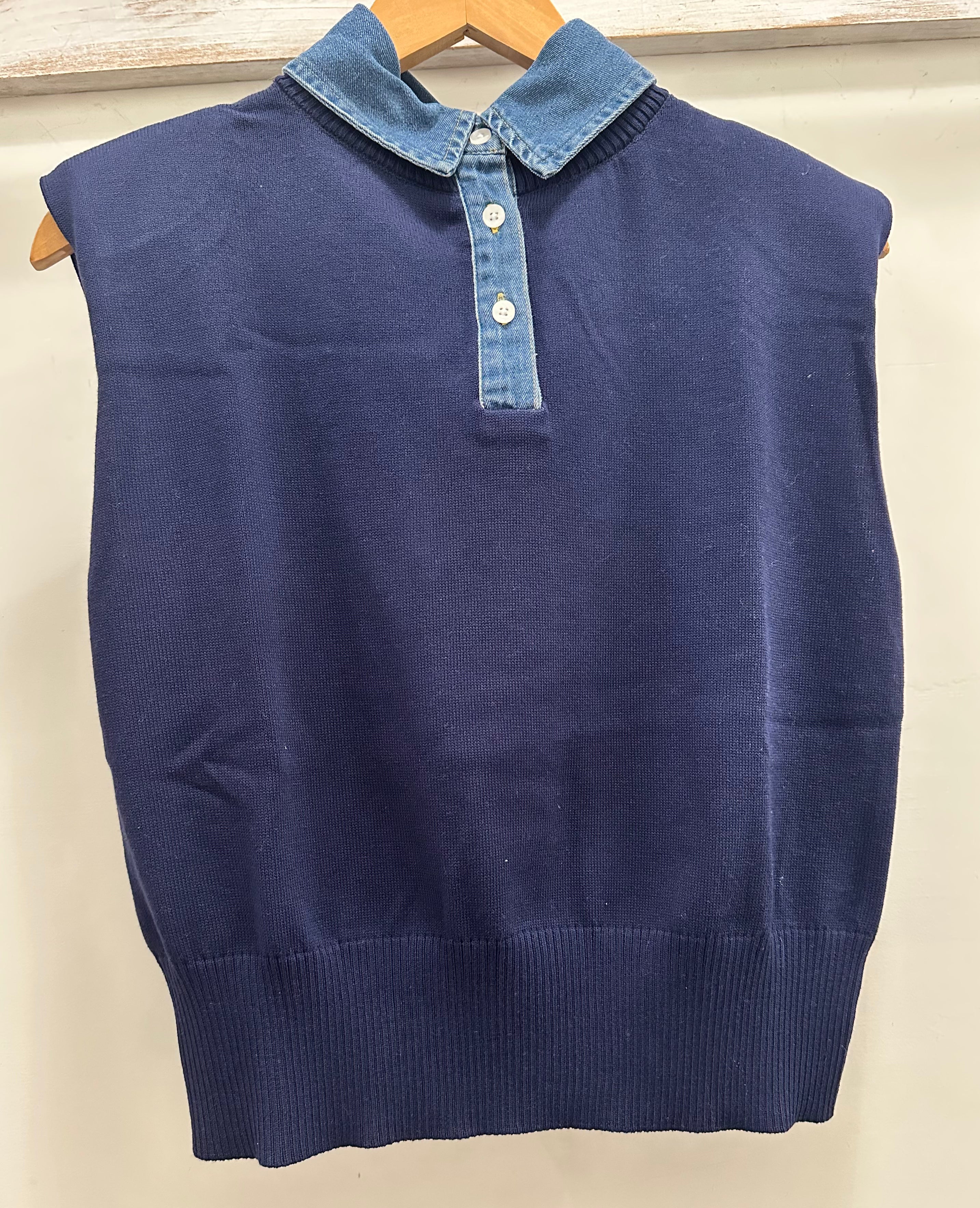 Blue sweater vest with denim collar on a hanger against a white background