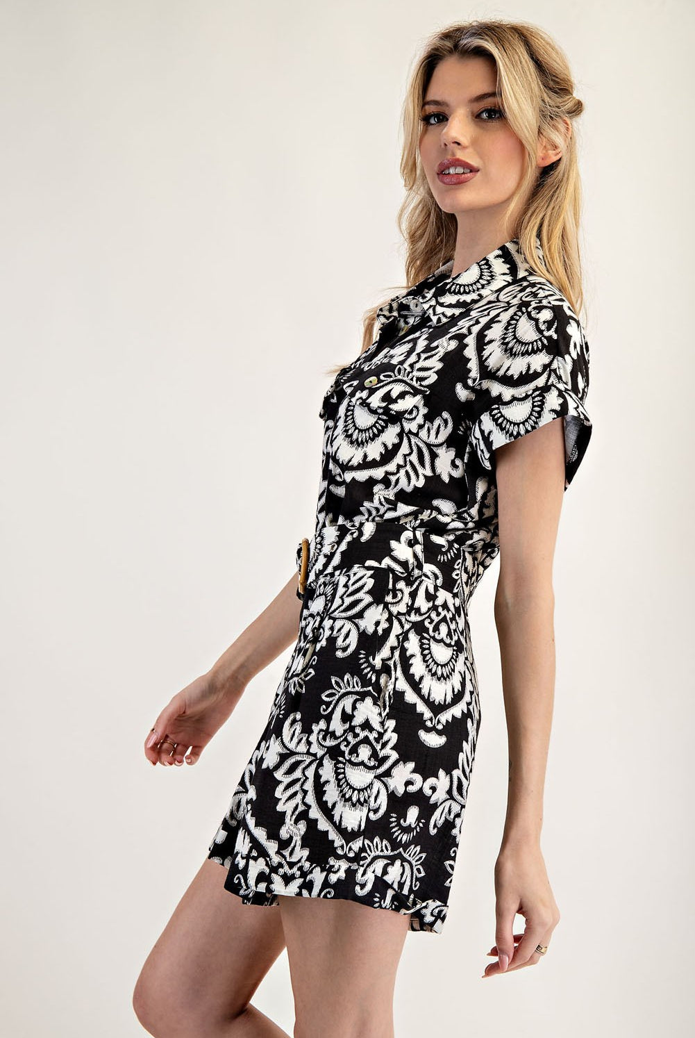 Woman wearing a black and white patterned dress on a white background