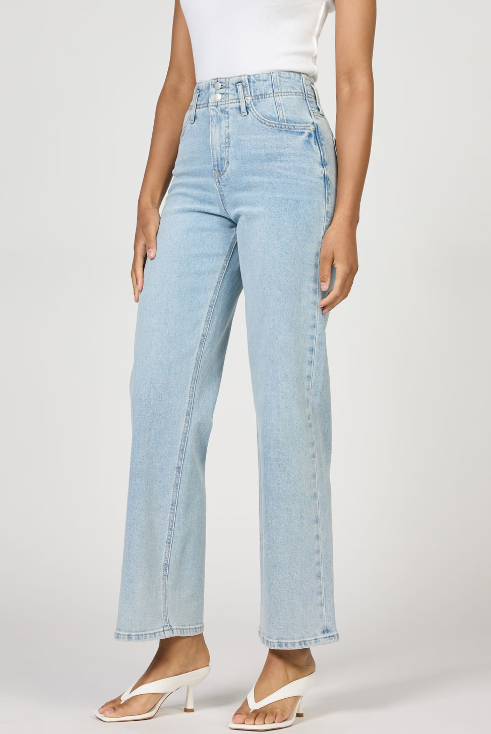 Light blue jeans worn by a person on a plain background