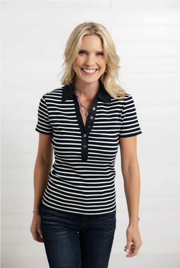 Woman wearing a black and white striped shirt with a plain background