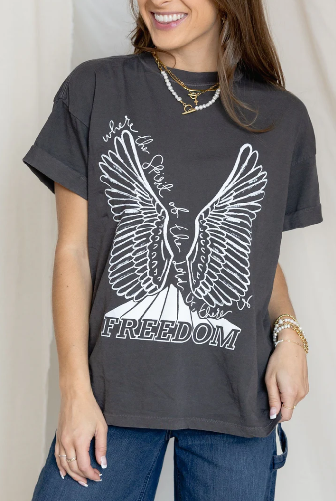 Person wearing a dark gray t-shirt with a white eagle design and 'Where the Spirit of Freedom Flies' text.