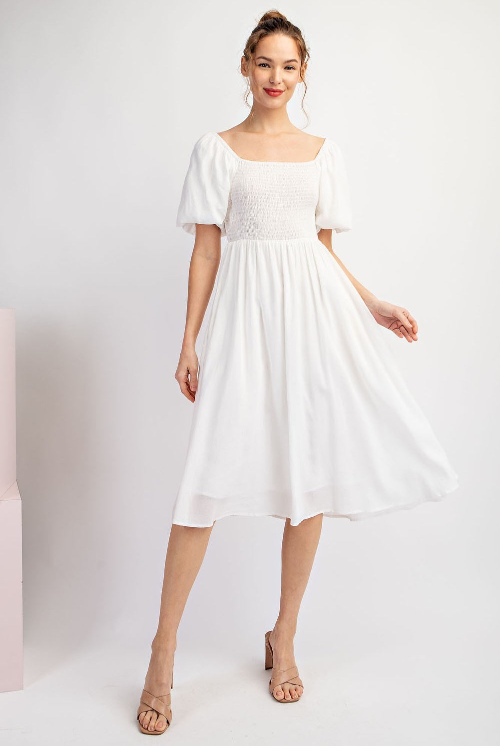 Woman wearing a white dress against a white background