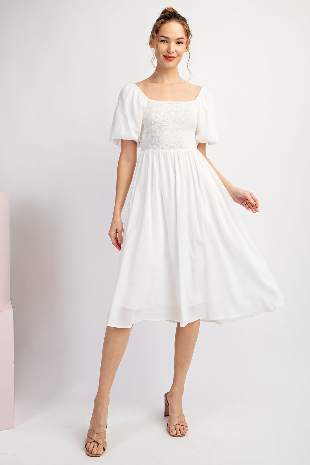 Woman wearing a white dress against a white background