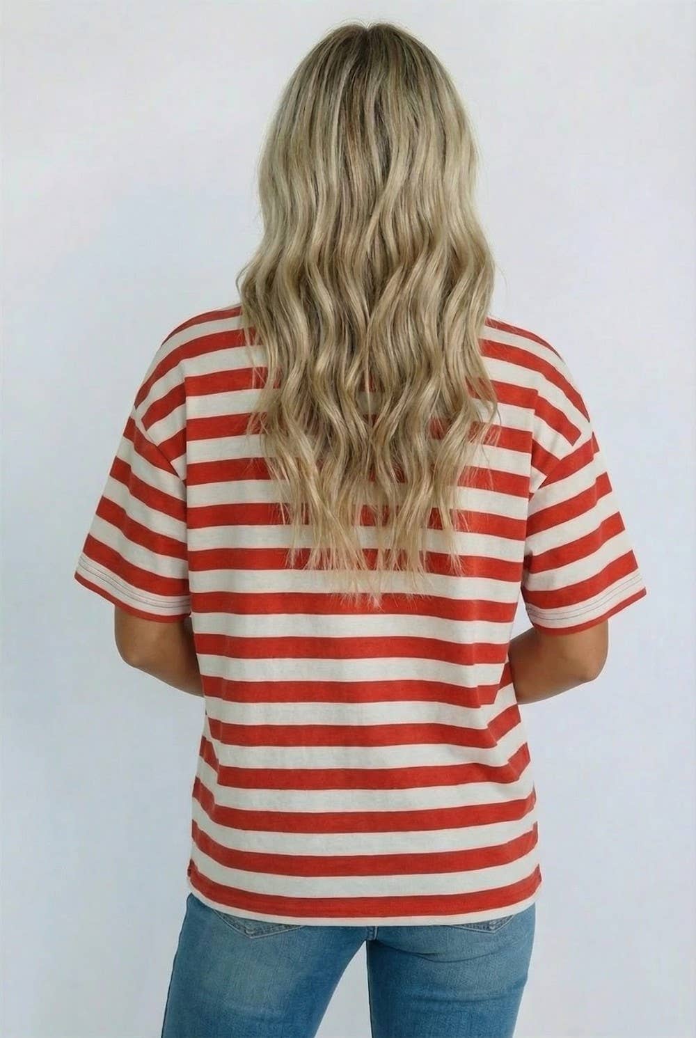Person wearing a red and white striped shirt with a plain background