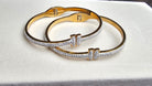 Two gold and silver bracelets on a white surface