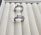 Two silver rings with gemstones on a beige jewelry box