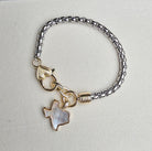 Bracelet with a mother-of-pearl Texas charm on a light gray background