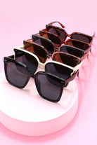 Set of sunglasses with different lens colors on a pink background