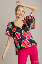 Woman wearing a colorful floral blouse with black background