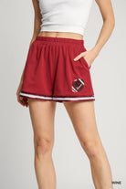 Red shorts with a football design on a white background