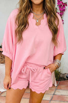 Person wearing a pink outfit with shorts and a top, standing outdoors.