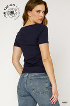 Woman wearing a navy t-shirt and blue jeans on a white background