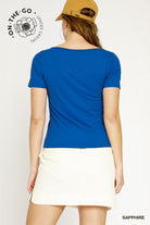 Woman wearing a blue t-shirt and beige cap on a white background with 'On-The-Go' branding.