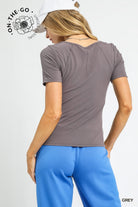 Woman wearing a gray t-shirt and blue pants on a white background with 'On-The-Go' branding.