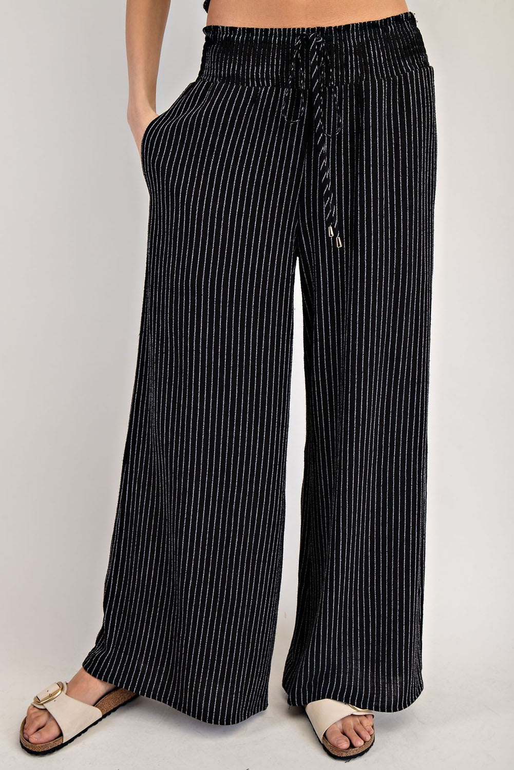 Black pinstripe straight-leg pants, back view
