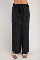 Black pinstripe pants with smocked drawstring waist and side pockets, angled view