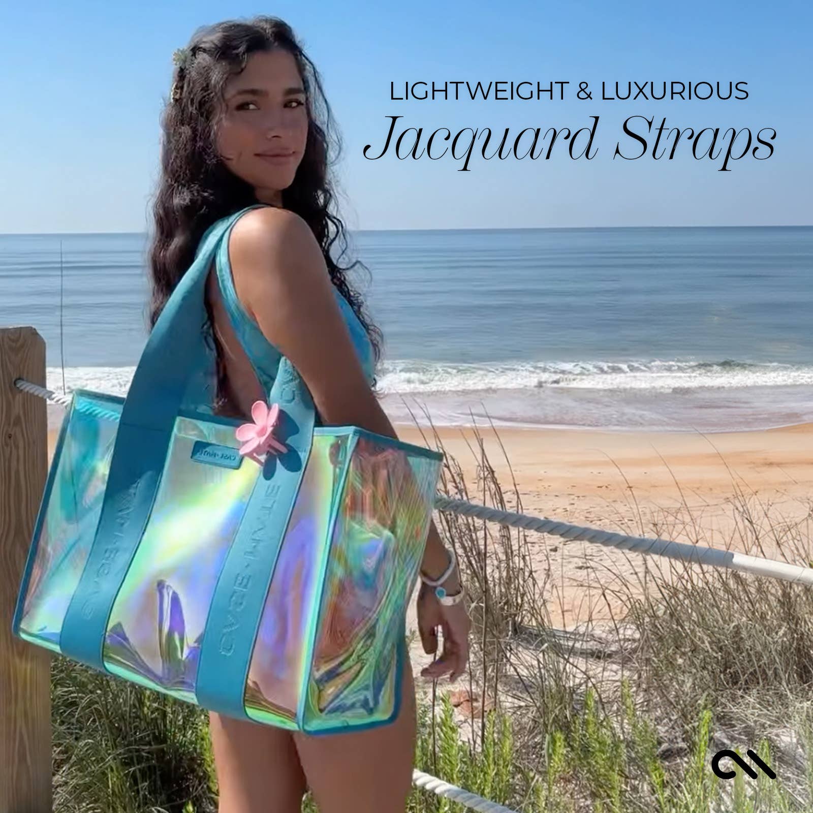 Woman holding a transparent beach bag with turquoise straps on a beach.