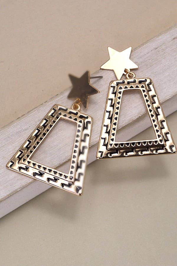 Gold geometric earrings on a beige surface