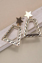 Gold geometric earrings on a beige surface