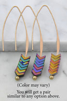 Colorful chevron-patterned earrings on a marble surface with text indicating color variation.