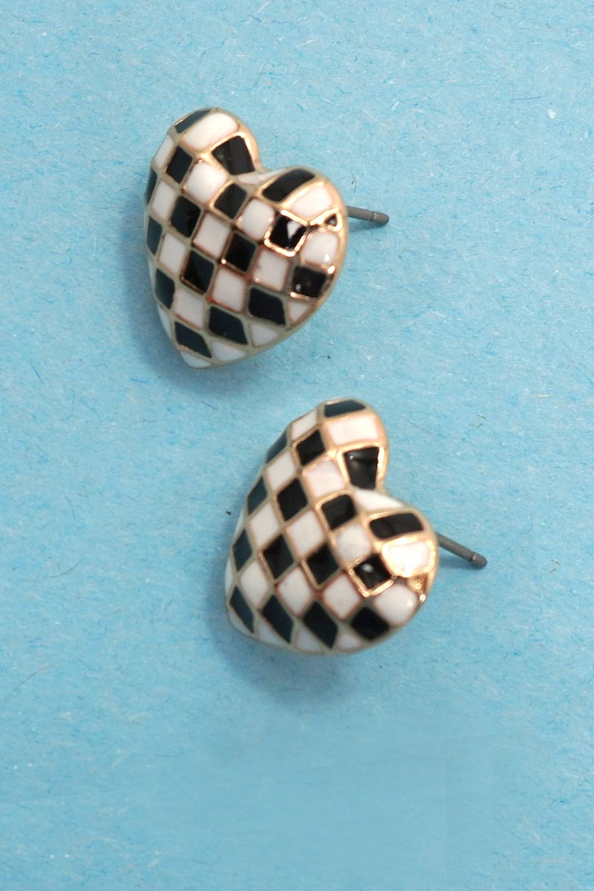 Checkered heart-shaped earrings on a blue background