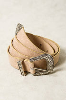 Beige belt with a decorative silver buckle on a light background