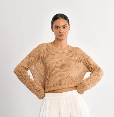 Woman wearing a beige knitted sweater on a white background