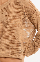 Close-up of a beige knit sweater on a white background