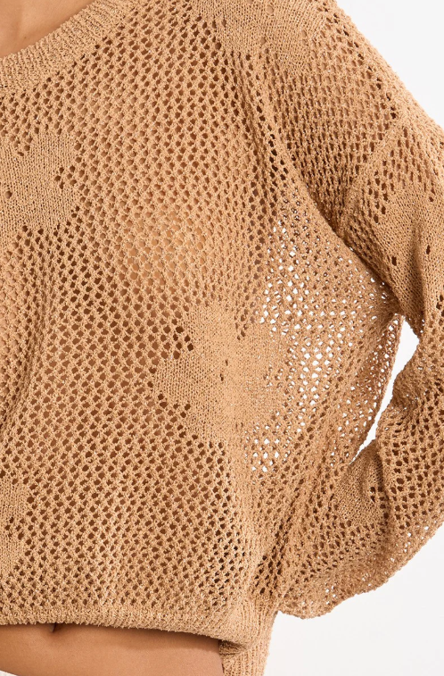 Close-up of a beige knit sweater on a white background