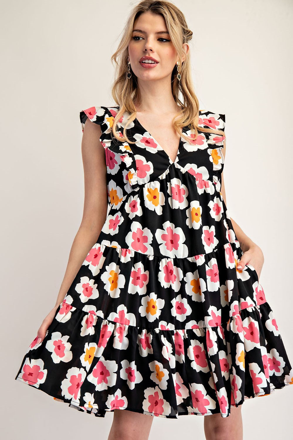 Woman wearing a black floral dress on a plain background