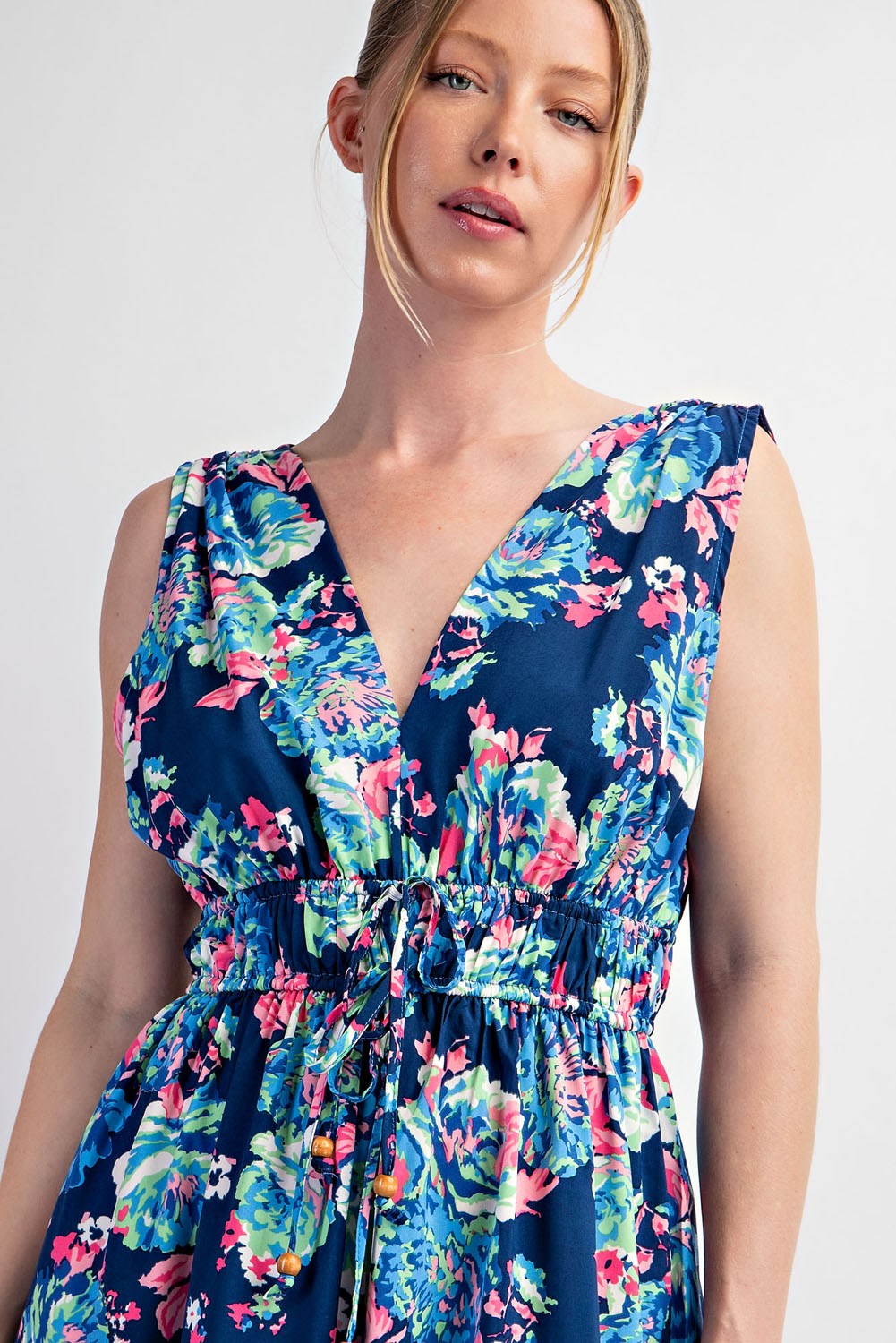 Woman wearing a navy floral dress against a white background