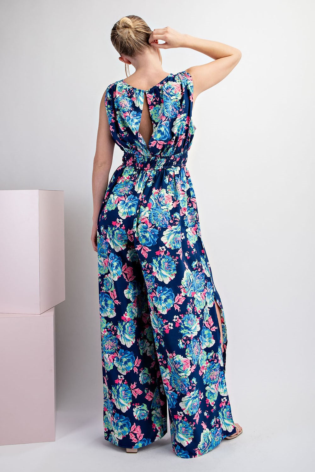 Woman wearing a floral jumpsuit with a white background