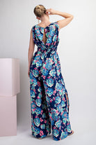 Woman wearing a floral jumpsuit with a white background