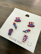 Set of patriotic earrings on a 'Thank You' card with a smiley face, displayed on a wooden surface.