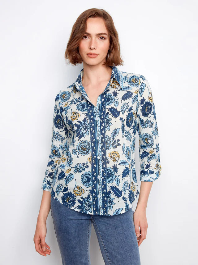 Woman wearing a blue floral shirt against a white background