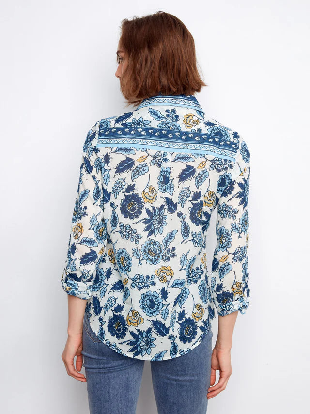Woman wearing a blue floral patterned shirt on a white background